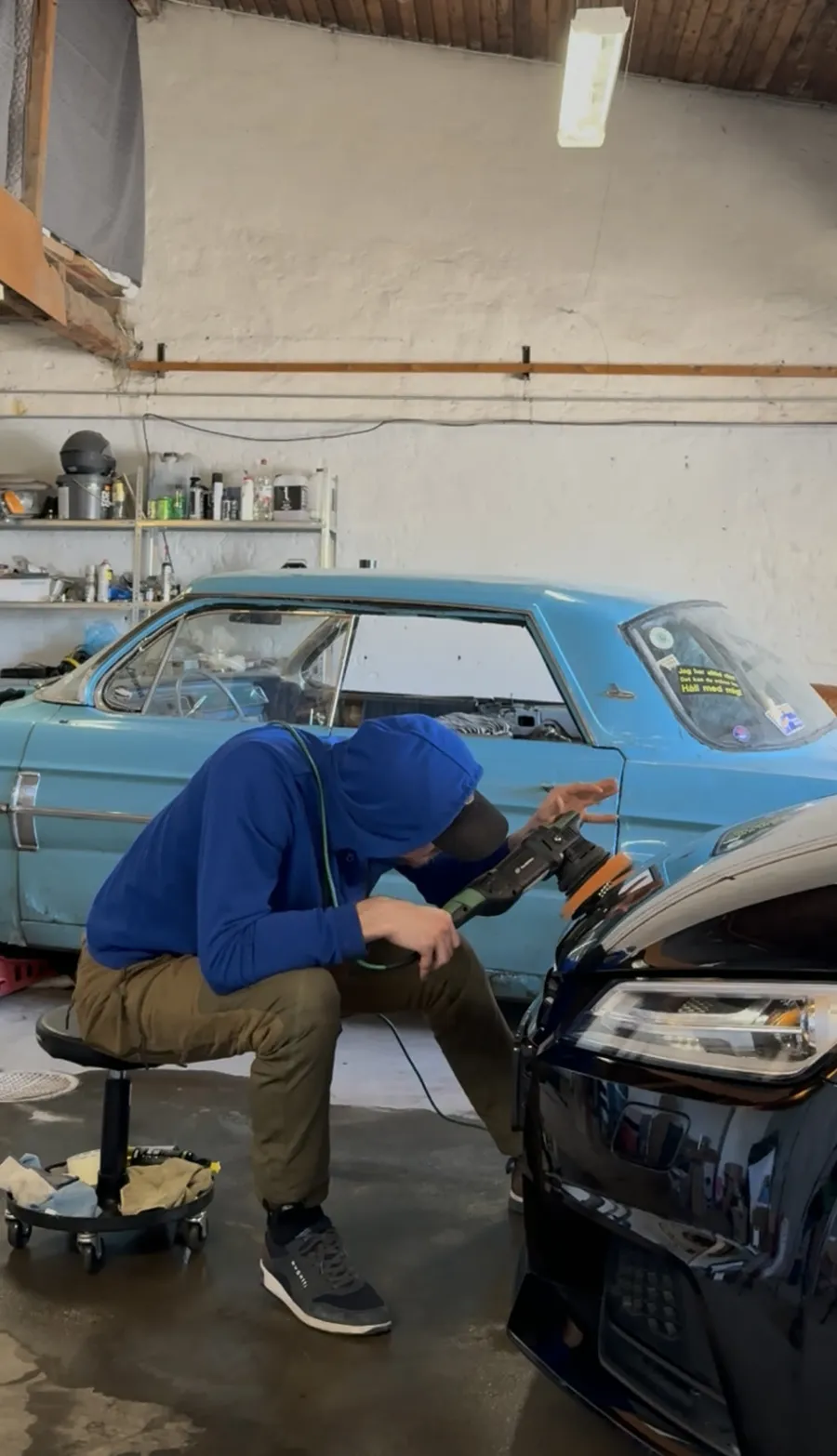 95Garage maskinpolerar en svart bil i verkstaden